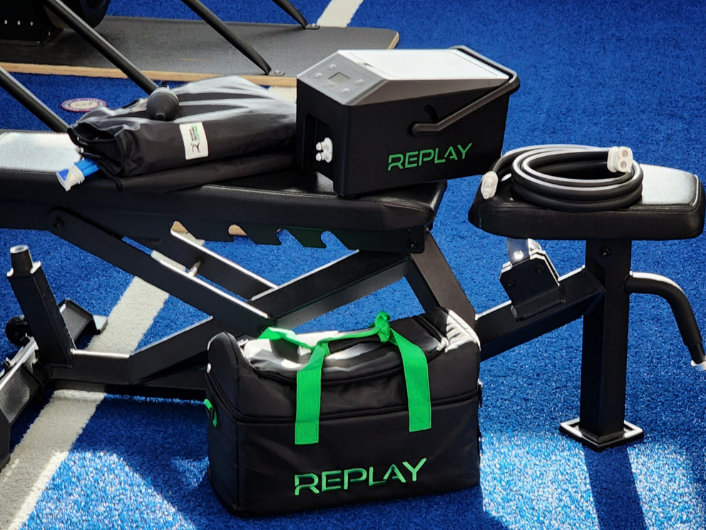 REPLAY compression therapy unit, hose, wrap and carry bag on gym benches